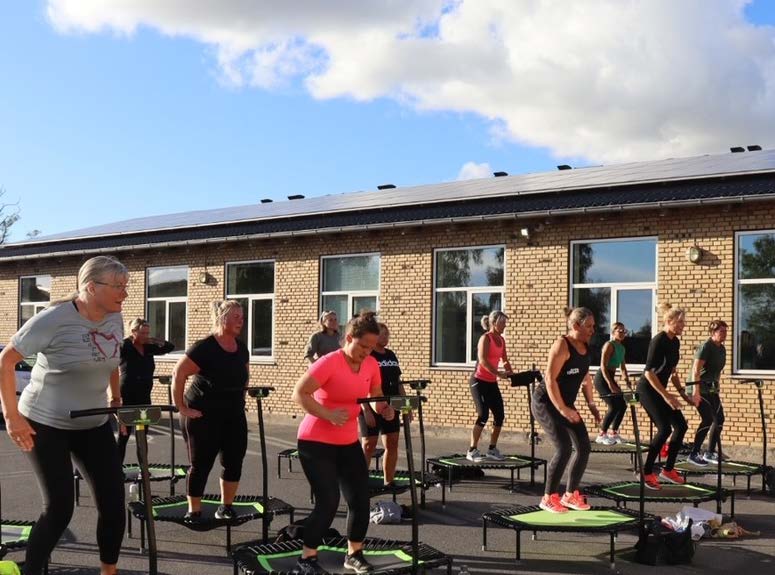 En forsamling mennesker er i fuld gang med en udendørs fitness time hos Foreningen Jump, dance and fitness Vestsjælland