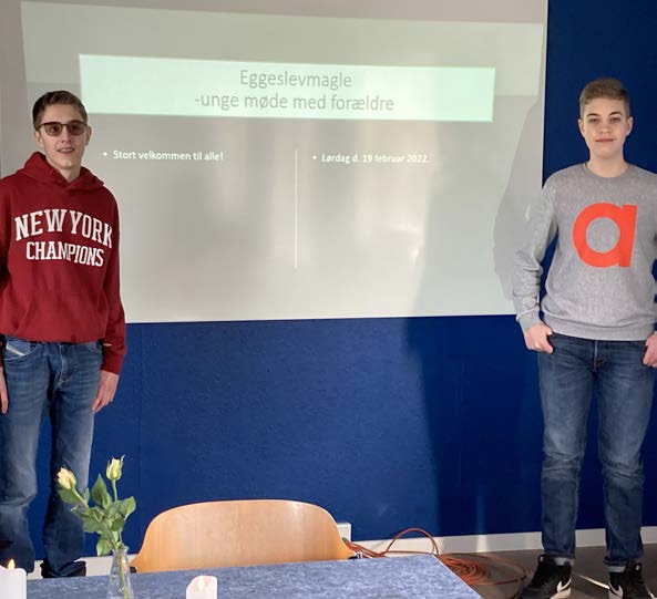 To unge mænd er ved at præsentere en slideshow til et møde med unge forældre